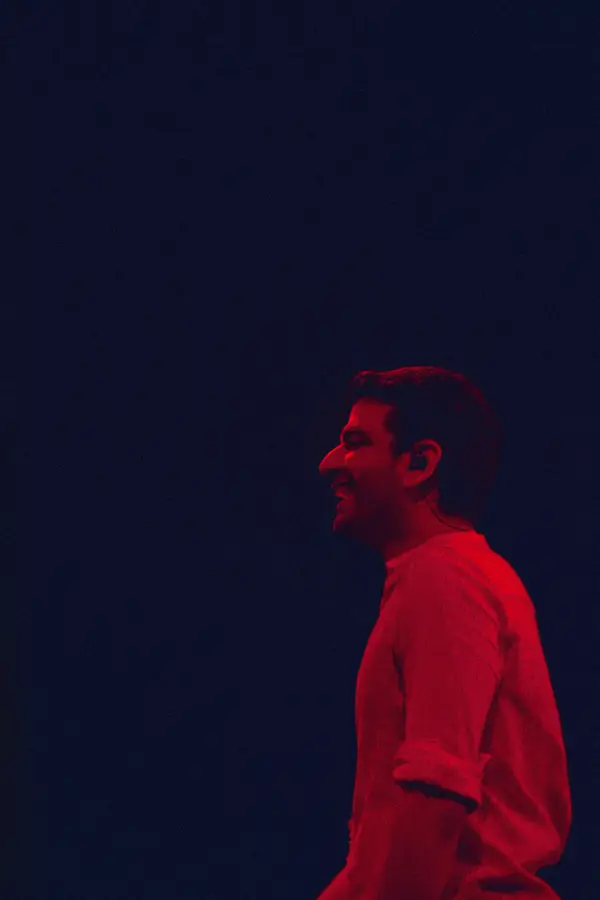 singer in profile against a dark blue stage